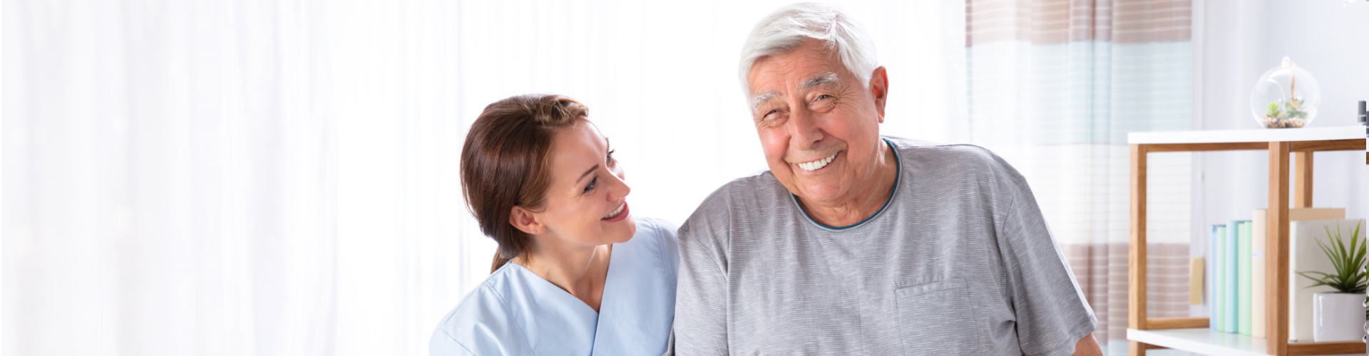 caregiver assisting senior man to stand