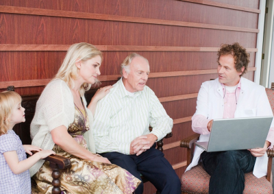 An elderly man and his family talking to a medical consultant